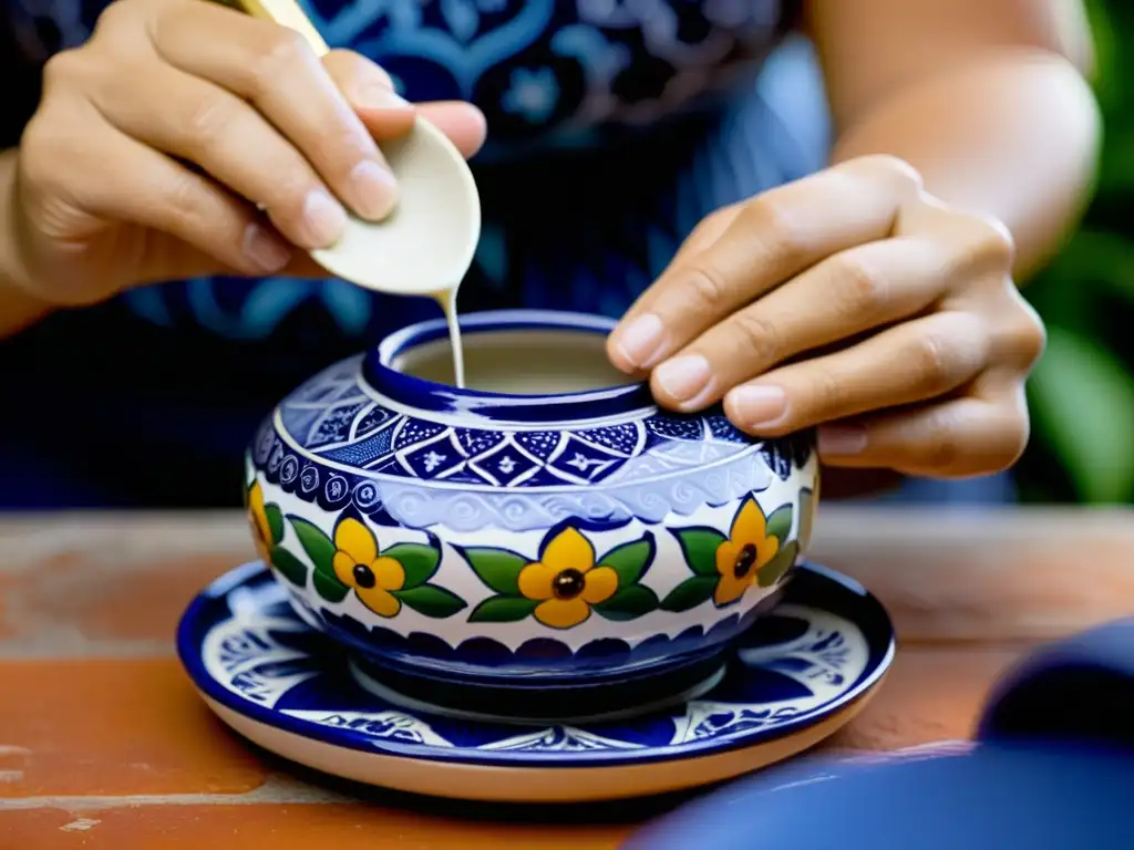 Un artesano experto pinta a mano patrones florales intrincados en cerámica de Talavera, mostrando el arte y funcionalidad de esta tradición